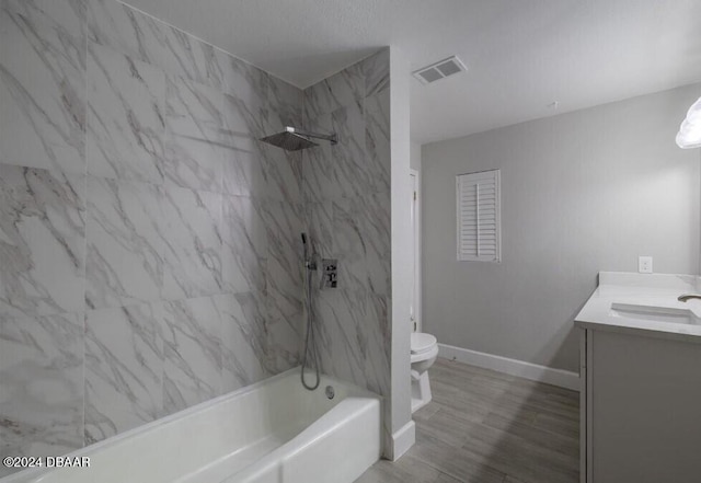 full bathroom featuring toilet, vanity, and tiled shower / bath combo