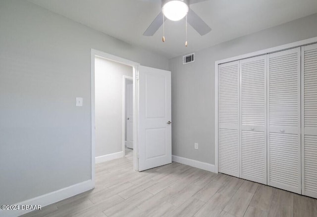 unfurnished bedroom with ceiling fan, a closet, and light hardwood / wood-style floors