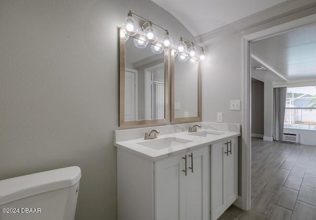 bathroom with toilet, vanity, and vaulted ceiling