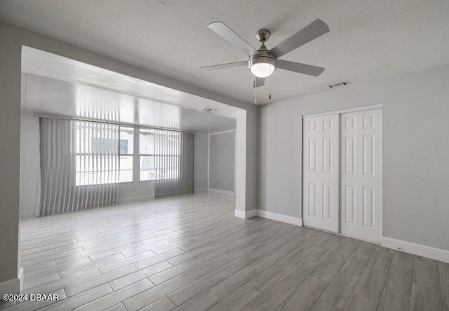 unfurnished room with a textured ceiling and ceiling fan