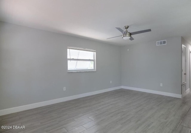 spare room with ceiling fan and light wood-type flooring