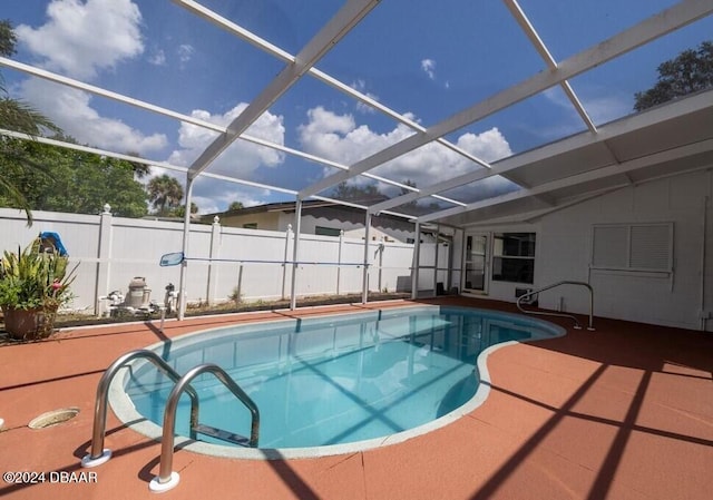 view of swimming pool featuring glass enclosure and a patio area