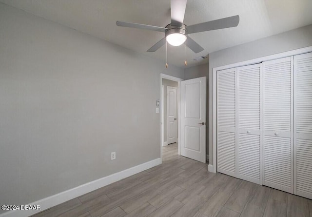 unfurnished bedroom featuring ceiling fan, a closet, and light hardwood / wood-style flooring