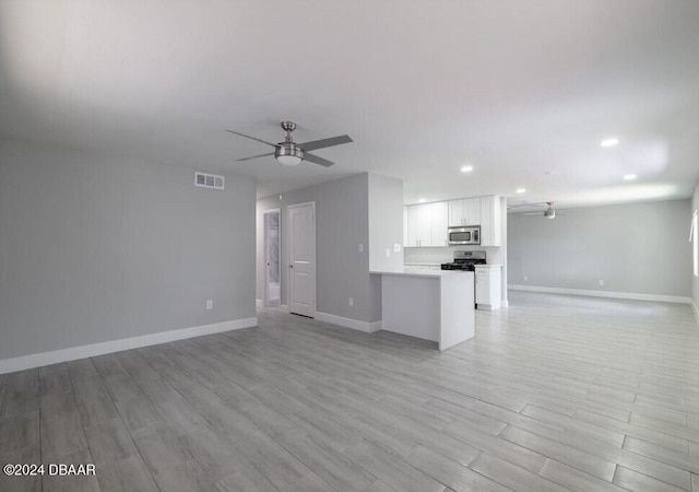 unfurnished living room featuring ceiling fan and light wood-type flooring