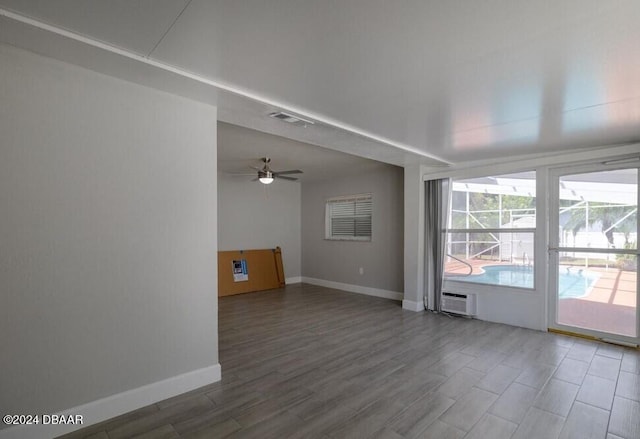 unfurnished room featuring ceiling fan and an AC wall unit