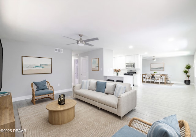 living room featuring ceiling fan and light hardwood / wood-style flooring