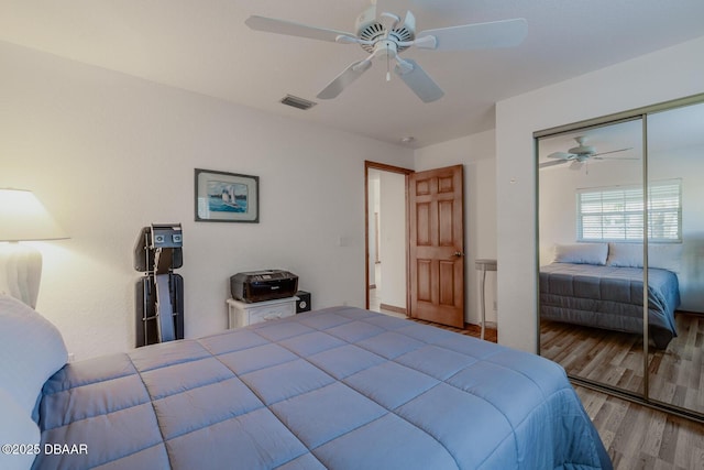 bedroom with hardwood / wood-style flooring, ceiling fan, and a closet