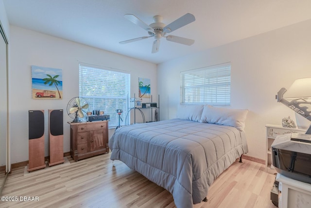 bedroom with multiple windows, ceiling fan, and light hardwood / wood-style flooring