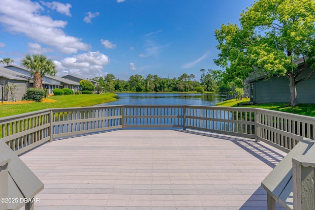 wooden deck with a lawn and a water view