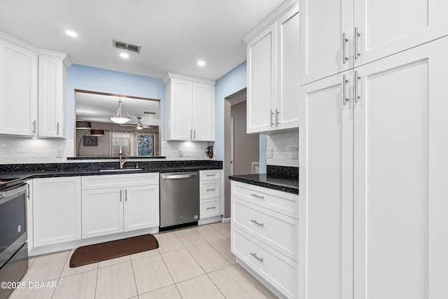 kitchen featuring sink, decorative backsplash, white cabinets, and appliances with stainless steel finishes