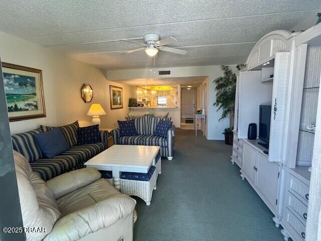 3800 S Atlantic Ave Unit 502, Daytona Beach, FL 32118 - living room featuring ceiling fan, dark colored carpet, and a textured ceiling
