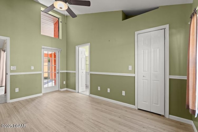 interior space with ceiling fan, high vaulted ceiling, and light hardwood / wood-style floors