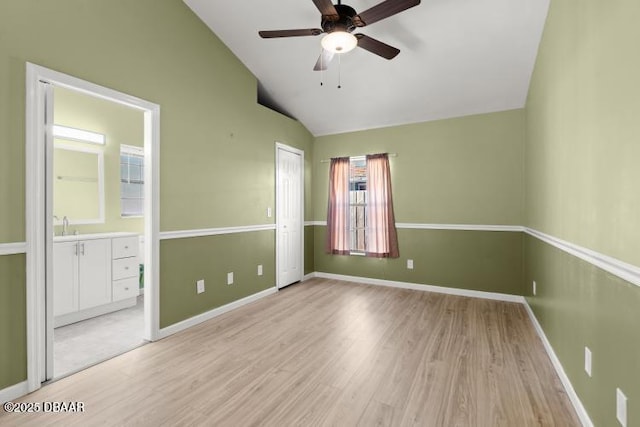 empty room featuring lofted ceiling, ceiling fan, and light hardwood / wood-style flooring