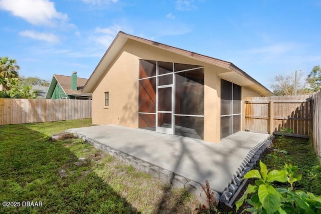 rear view of property with a patio, a sunroom, and a lawn