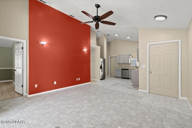 unfurnished living room with ceiling fan and high vaulted ceiling