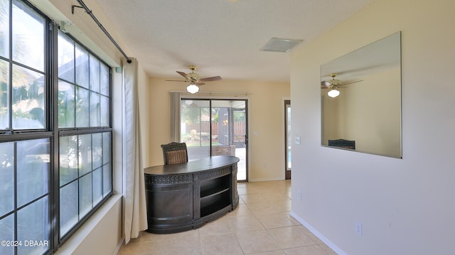 kitchen with ceiling fan, light tile patterned flooring, a healthy amount of sunlight, and a textured ceiling