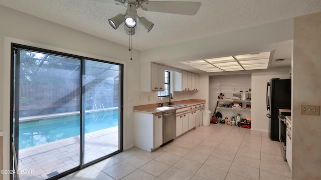 kitchen featuring white cabinets, sink, light tile patterned floors, ceiling fan, and stainless steel appliances