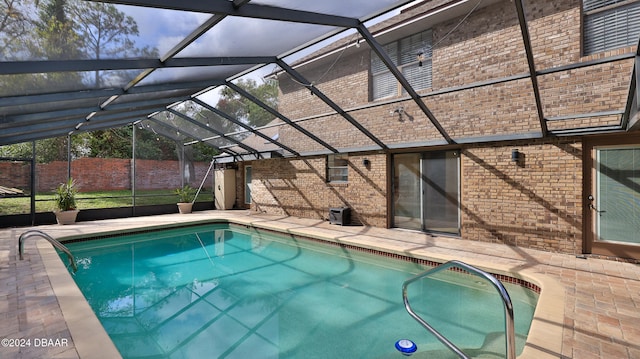 view of swimming pool featuring a lanai and a patio area