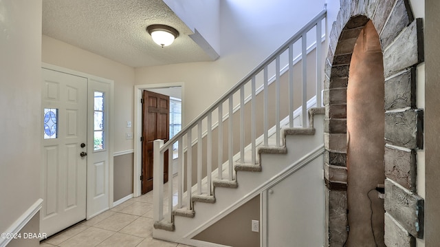 tiled foyer with a textured ceiling