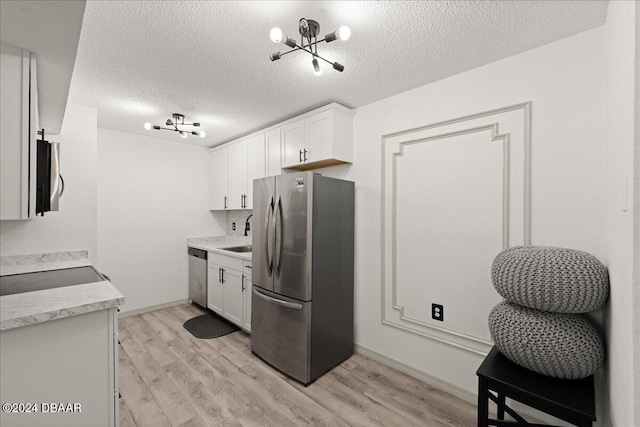 kitchen featuring white cabinets, a textured ceiling, light hardwood / wood-style flooring, and appliances with stainless steel finishes