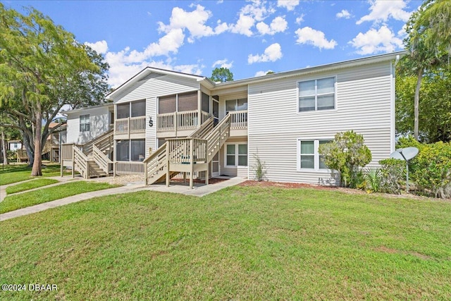 back of house featuring a sunroom and a yard