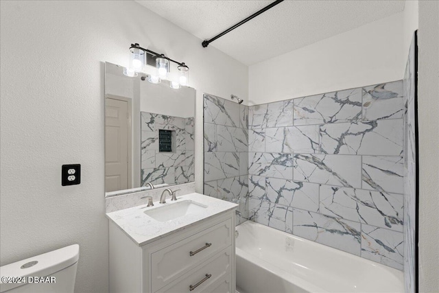 full bathroom featuring tiled shower / bath, a textured ceiling, toilet, and vanity