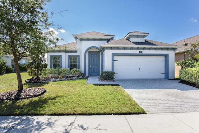 113 Azure Mist Way, Daytona Beach, FL 32124 - mediterranean / spanish-style house featuring decorative driveway, stucco siding, a front lawn, an attached garage, and a shingled roof