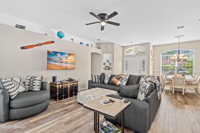 living area featuring visible vents, arched walkways, wood finished floors, and ceiling fan with notable chandelier