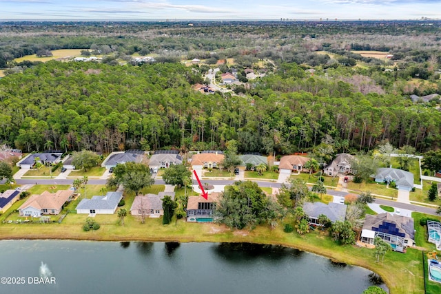 drone / aerial view featuring a forest view, a water view, and a residential view