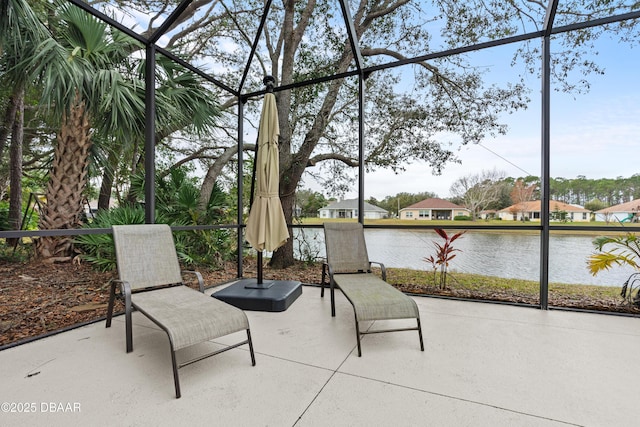 view of patio / terrace featuring glass enclosure and a water view