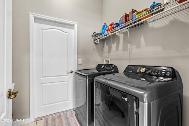 clothes washing area featuring washer and dryer, laundry area, and wood finished floors