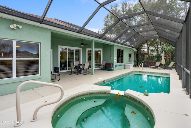 view of pool with glass enclosure, a patio area, a pool with connected hot tub, and ceiling fan