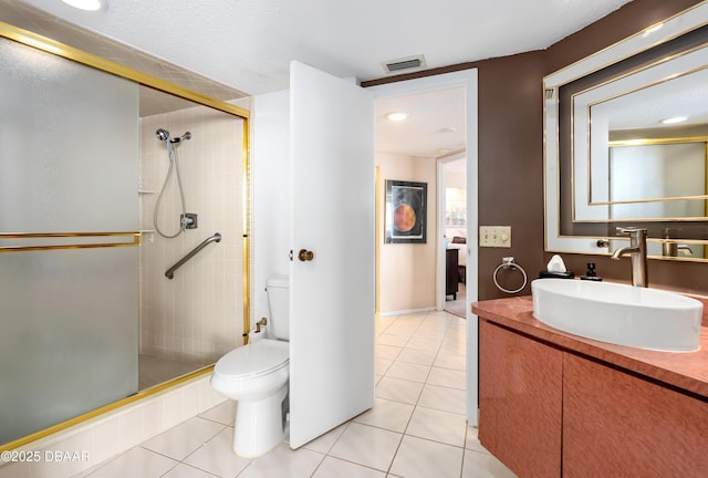 bathroom featuring tile patterned floors, vanity, toilet, and walk in shower