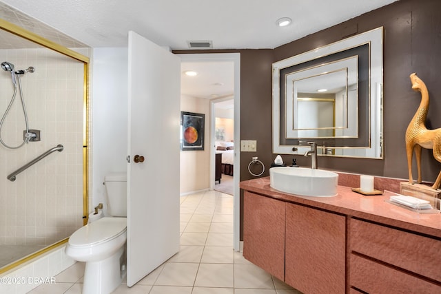 bathroom with tile patterned floors, vanity, toilet, and a shower with shower door