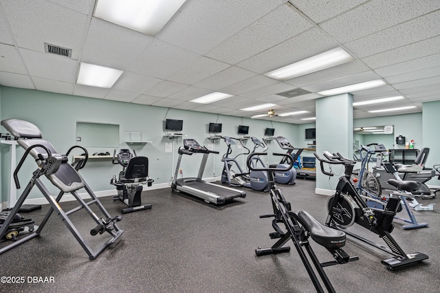 exercise room with a paneled ceiling and ceiling fan