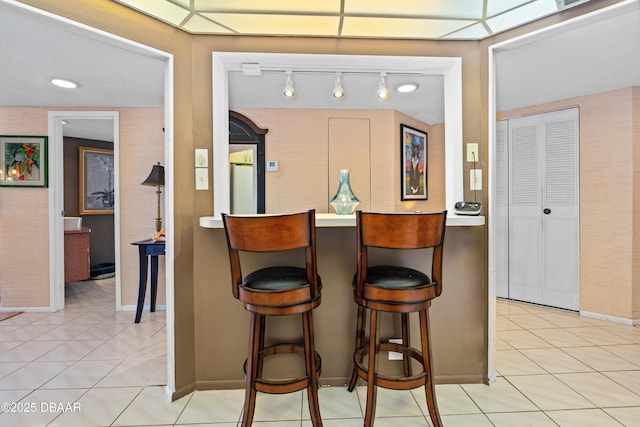 kitchen with a kitchen bar and light tile patterned floors