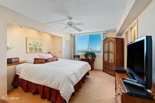 carpeted bedroom with ceiling fan, a closet, and a textured ceiling