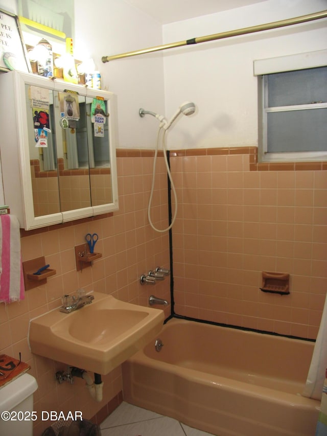 55 Seaside Dr, Ormond Beach, FL 32176 - full bath with tile walls, bathtub / shower combination, and a wainscoted wall