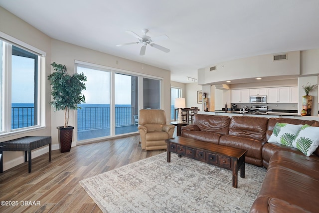3737 S Atlantic Ave Unit 702, Daytona Beach, FL 32118 - living area featuring ceiling fan, plenty of natural light, and light wood-style flooring