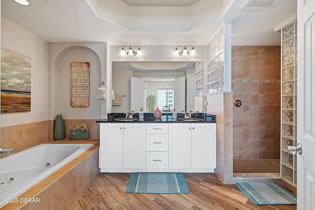 3737 S Atlantic Ave Unit 702, Daytona Beach, FL 32118 - bathroom featuring a tub with jets, walk in shower, double vanity, and wood finished floors