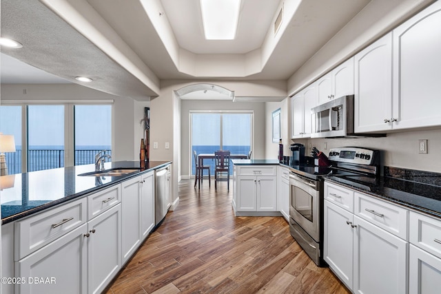 3737 S Atlantic Ave Unit 702, Daytona Beach, FL 32118 - kitchen with stainless steel appliances, white cabinets, light wood-style flooring, and recessed lighting