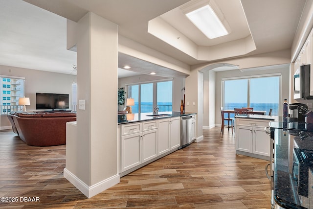 3737 S Atlantic Ave Unit 702, Daytona Beach, FL 32118 - kitchen with stainless steel appliances, wood finished floors, white cabinetry, open floor plan, and recessed lighting