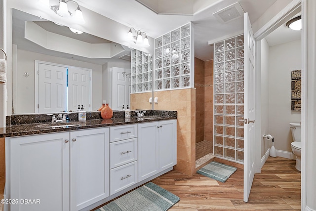 3737 S Atlantic Ave Unit 702, Daytona Beach, FL 32118 - bathroom with walk in shower, double vanity, wood finished floors, tile walls, and a tray ceiling