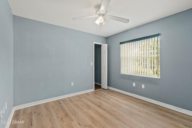 unfurnished room with baseboards, wood finished floors, and a ceiling fan