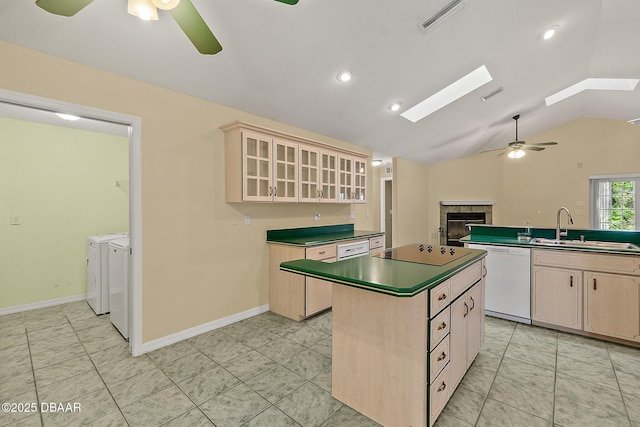 kitchen featuring a fireplace, separate washer and dryer, white dishwasher, a sink, and ceiling fan