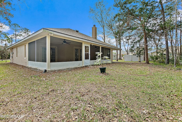 rear view of house featuring a ceiling fan, fence, a yard, a sunroom, and a chimney