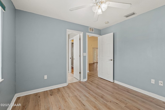 unfurnished bedroom with visible vents, baseboards, and wood finished floors