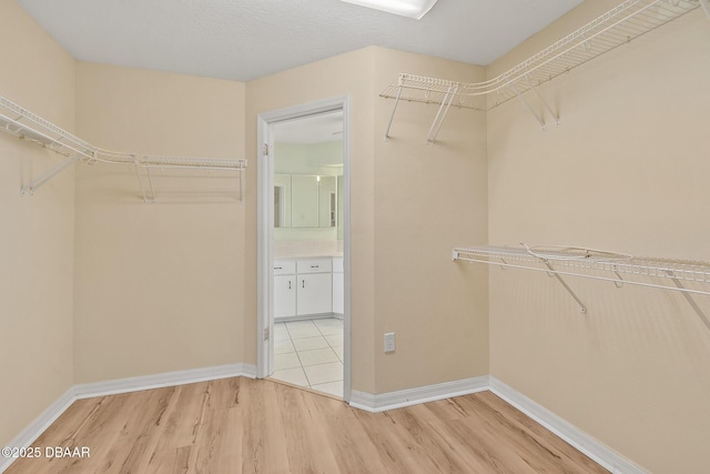 walk in closet with wood finished floors