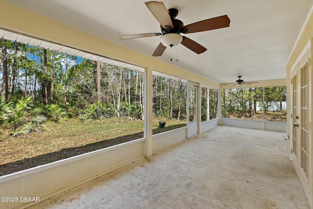 unfurnished sunroom with ceiling fan