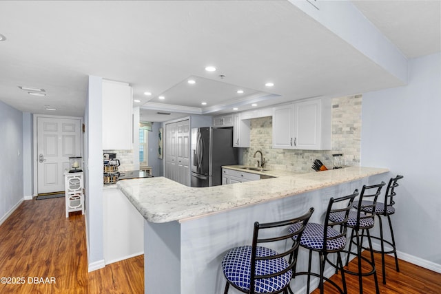 3333 S Atlantic Ave Unit 1802, Daytona Beach, FL 32118 - kitchen with stainless steel fridge with ice dispenser, decorative backsplash, dark wood-type flooring, a kitchen bar, and recessed lighting